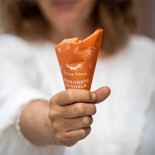 Orangene Tüte mit gebrannten Mandeln